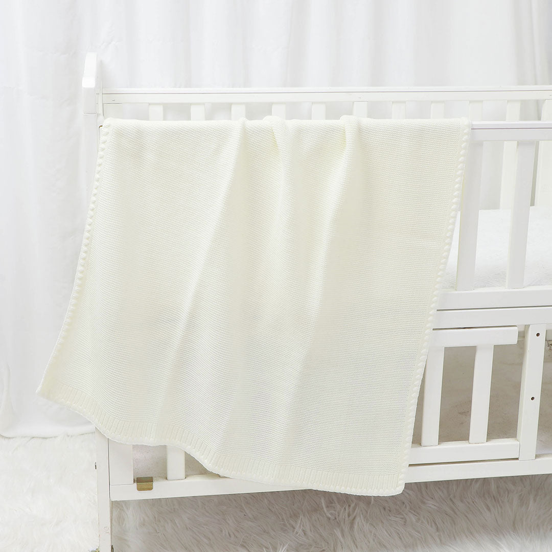 Aspen-Knit-Baby-Blanket-on-cot