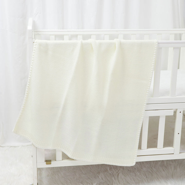 Aspen-Knit-Baby-Blanket-on-cot