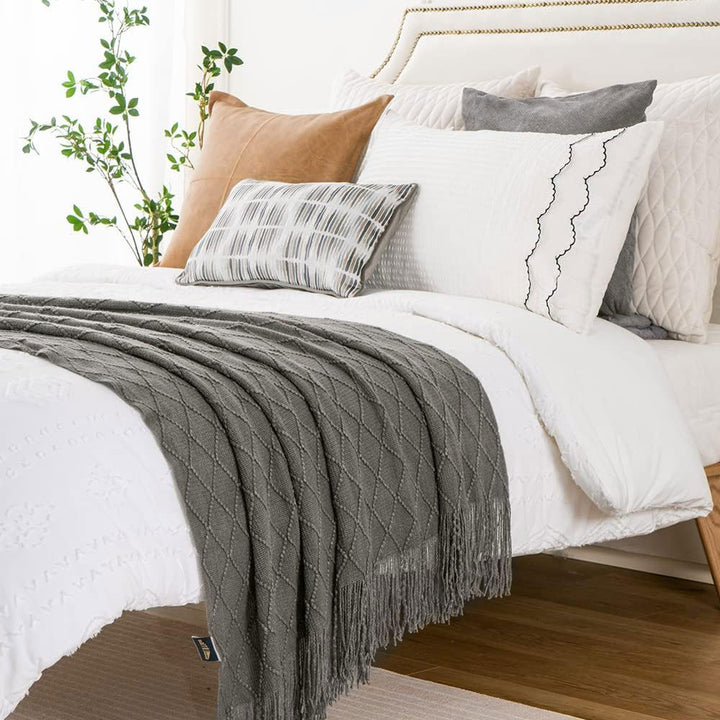 Knit Throw Blanket with Tassels in Grey Color. On bed. Size 130-150 cm